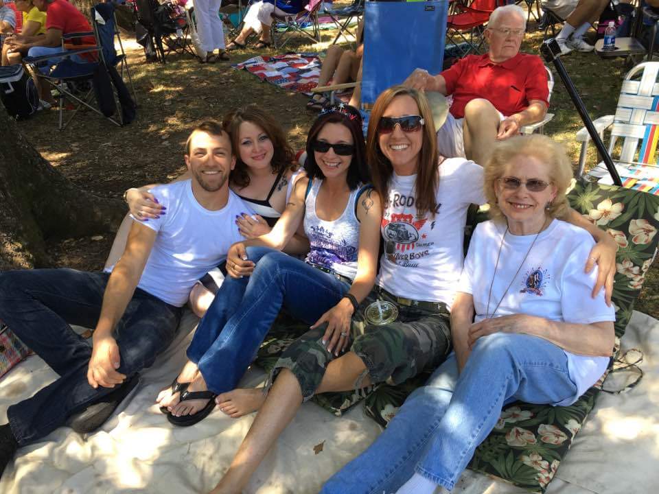 Image may contain: 7 people, people smiling, people sitting and outdoor